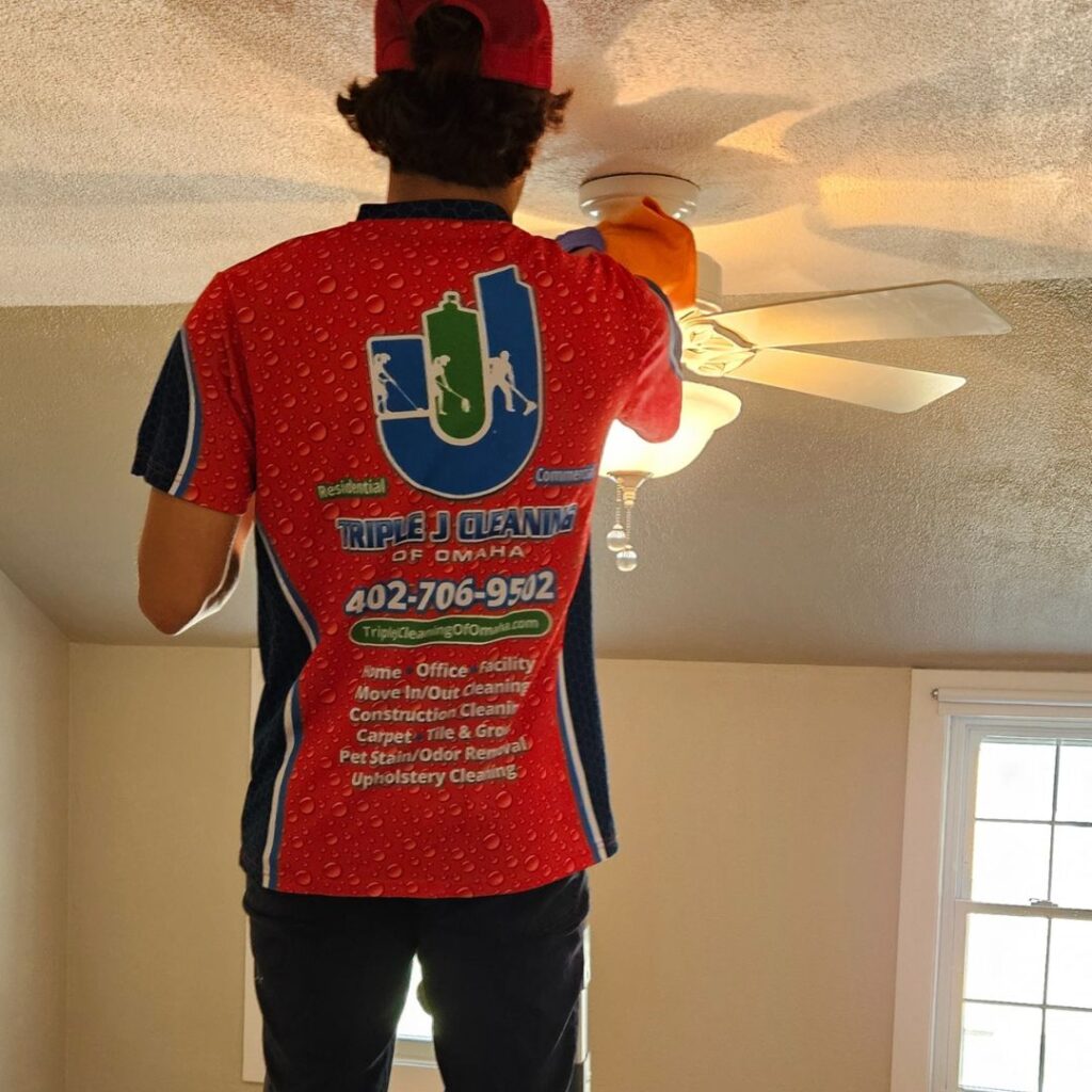 Triple J Cleaning of Omaha technician dusting ceiling fan during detailed deep house cleaning in Elkhorn Nebraska