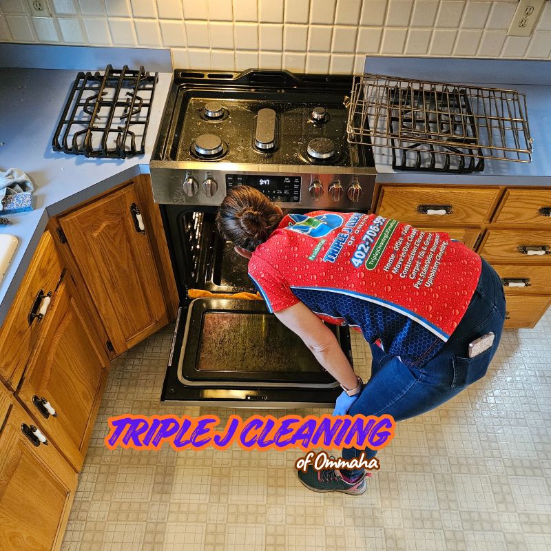 A professional cleaner from Triple J Cleaning of Omaha performs an oven deep clean in a local kitchen. We specialize in residential cleaning services, including move-out cleaning in Bellevue NE and appliance cleaning.