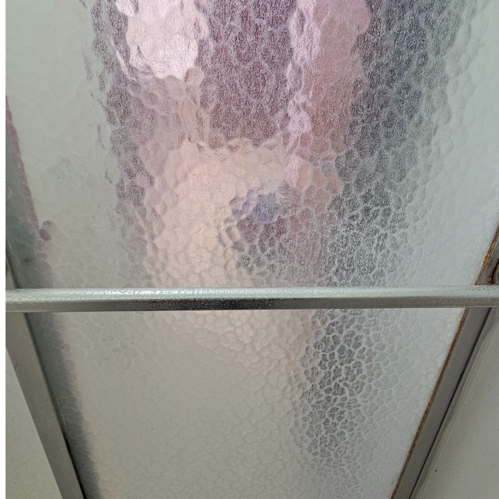 hard water stained shower glass door before cleaning Omaha NE bathroom deep cleaning hard water removal Triple J Cleaning Omaha